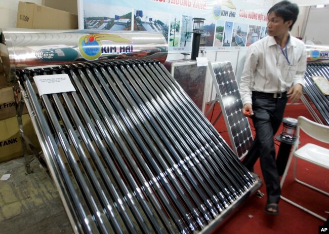 FILE - A solar water heater, left, and a solar panel, right, are seen at Entech Hanoi, an international trade fair on energy efficiency and the environment, at the Giang Vo Exhibition Center in Hanoi, Vietnam.